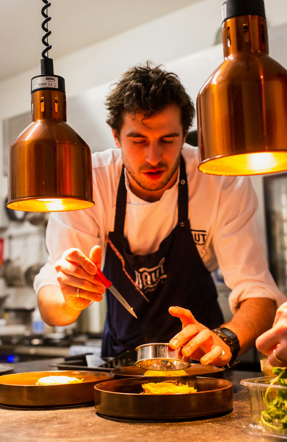 Profissional preparando alimentos em uma cozinha gastronômica
